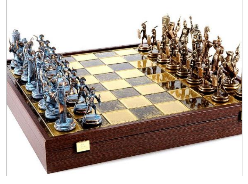 Szachownica z kompletem stylizowanych figur, srebrnych po jednej stronie i złotych po drugiej, ustawionych w pozycjach początkowych.